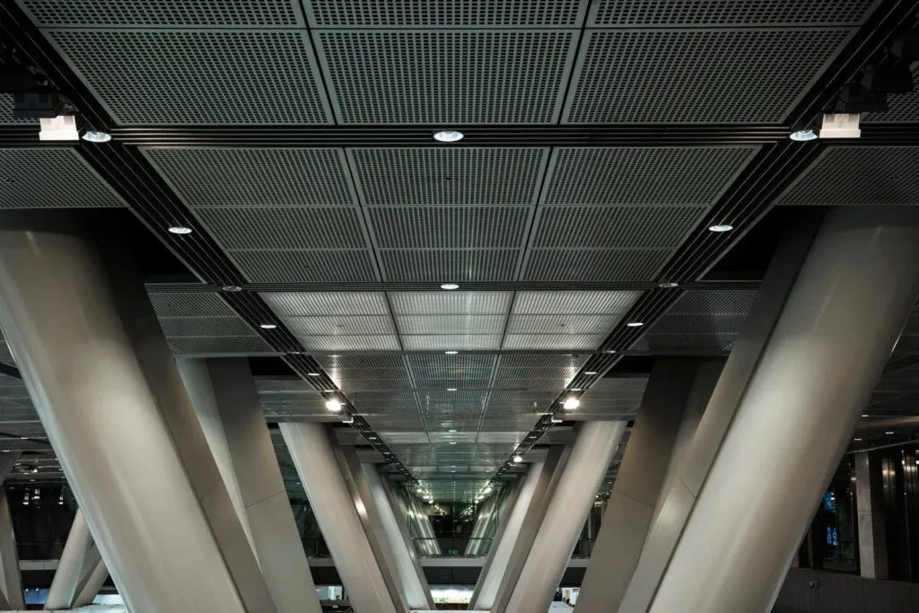 Industrial ceiling with linear track lighting and recessed spotlights
