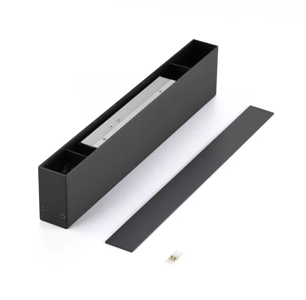 Surface-mounted black linear LED light housing with removable cover, internal heat sink, and mounting connectors on a white background